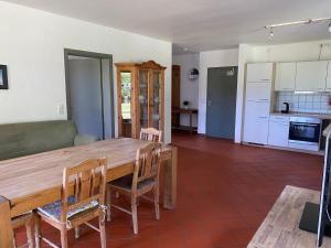 eine Küche und ein Esszimmer mit einem Holztisch und Stühlen in der Unterkunft Hofgut Wollin GmbH in Putgarten
