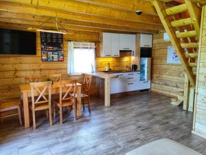 uma cozinha com uma mesa e cadeiras num camarote em Chatki U Hanusi em Czchów