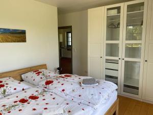 ein Schlafzimmer mit zwei Betten mit roten Blumen drauf in der Unterkunft Hofgut Wollin GmbH in Putgarten