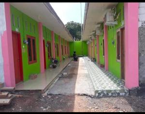 einen leeren Flur eines Gebäudes mit grünen und rosa Wänden in der Unterkunft Hotel Near Ramayana 3 in Pekalongan