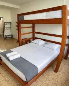 um quarto com um beliche com lençóis brancos em Magdalen House Tarapoto em Tarapoto