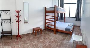Dormitorio pequeño con litera y silla en Magdalen House Tarapoto, en Tarapoto