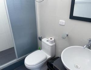 een badkamer met een toilet, een wastafel en een douche bij Magdalen House Tarapoto in Tarapoto