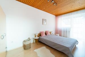 1 dormitorio con 1 cama con techo de madera en Reneček - rekreační řadový dům s vyhlídkou na Libín, en Prachatice