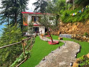 a house on a hill with a tree in the yard at TAG's Stay, Naggar in Nagar