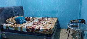 ein kleines Bett in einem Zimmer mit blauer Wand in der Unterkunft Hotel Near Ramayana 3 in Pekalongan
