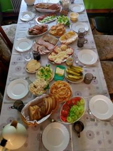 una mesa larga con platos de comida. en Agroturystyka u Basi, en Burniszki