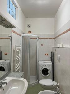 La salle de bains est pourvue d'un lavabo et d'un lave-linge. dans l'établissement Savona Sant'antonio Mare Clima WiFi, à Savone