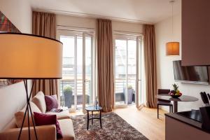 a living room with a couch and a table at The Wellem Residences in Düsseldorf