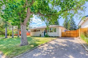 a house with a fence and a tree at Luxury Home By North Glenmore Park in Calgary