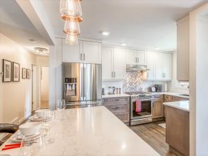 a kitchen with white cabinets and a marble counter top at Luxury Home By North Glenmore Park in Calgary