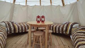 pokój z 2 łóżkami i stołem w namiocie w obiekcie Glamping Wild Nature Bałtów w Bałtowie