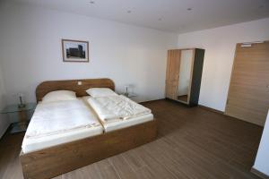 a bedroom with a bed with a wooden headboard at Boardinghouse Schellenberg in Donauwörth