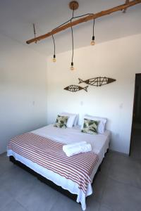 - une chambre avec un lit et une couverture rayée dans l'établissement Pousada Movimento, à Prea