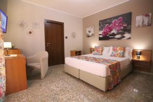 a hotel room with a bed and a chair at Secondo Binario in Amantea +35 photos
