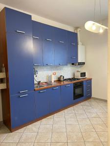a kitchen with blue cabinets and a sink at Savona Sant'antonio Mare Clima WiFi in Savona