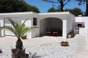 una casa blanca con una palmera en el patio en Casa do Cipreste, en Viana do Castelo