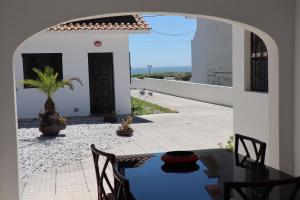 Un patio con una mesa y sillas en una casa. en Casa do Cipreste, en Viana do Castelo