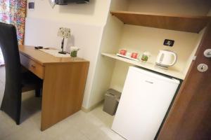 a small office with a desk and a refrigerator at Secondo Binario in Amantea