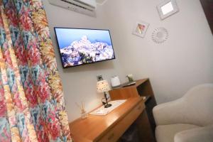 a bedroom with a bed and a tv on a wall at Secondo Binario in Amantea