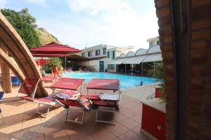 a group of tables and chairs next to a swimming pool at Secondo Binario in Amantea