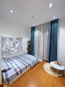 a bedroom with a bed with blue curtains and a table at Mộc Homestay 1 in Ấp Ðông An (1)
