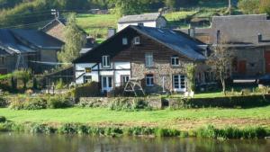 una casa accanto a un fiume con case di Gîte la Passerelle à Mouzaive a Vresse-sur-Semois