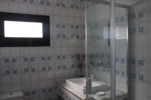 Un baño con lavabo y ducha de cristal. en Casa do Cipreste, en Viana do Castelo 27 fotos más