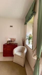 un soggiorno con sedia bianca e finestra di Casa di famiglia a Casaletto Spartano