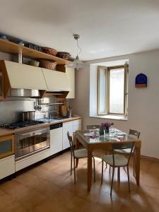una cucina con tavolo, sedie e piano cottura di Casa di famiglia a Casaletto Spartano