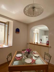 uma sala de jantar com uma mesa e um espelho em Casa di famiglia em Casaletto Spartano