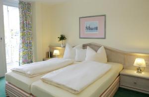 バート・ビルンバッハにあるHaus am Kurparkのベッドルーム1室(ベッド2台、白い枕付)