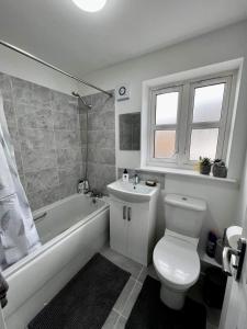 a bathroom with a toilet and a tub and a sink at North Colchester Homestay in Mile End