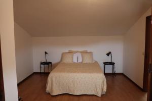 1 dormitorio con 1 cama con 2 lámparas en 2 mesas en Casa do Cipreste, en Viana do Castelo
