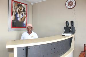 a man standing in front of a reception desk at Unit G Guest House in Ga-Mothiba