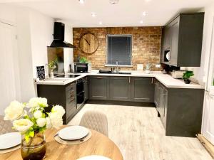 a kitchen with black cabinets and a wooden table at Lakeside View With Hot Tub in Abertillery