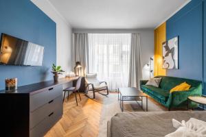 a living room with a green couch and a desk at Loong Refresh Old Town in Prague