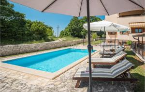 - une piscine avec un parasol et deux chaises dans l'établissement Nice Home In Porec With Wifi, à Poreč