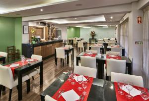 a restaurant with black tables and white chairs and red napkins at Parque Mourabel, Oásis Village & Pé do Lago in Vilamoura
