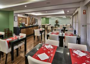 a restaurant with black tables and white chairs and red napkins at Parque Mourabel, Oásis Village & Pé do Lago in Vilamoura