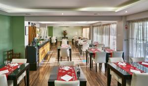 a restaurant with tables and chairs in a room at Parque Mourabel, Oásis Village & Pé do Lago in Vilamoura