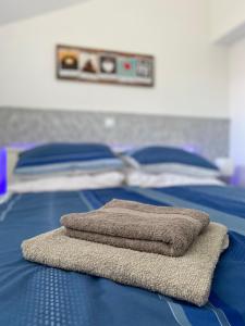 two towels sitting on top of a blue bed at Albert apartments Zagreb airport in Velika Gorica