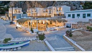 a large building with a boat in front of it at Ypsilos Beach Suites in Kyra Panagia