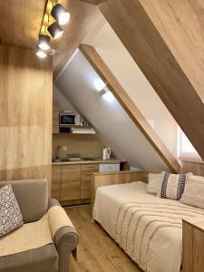 NevSki Apartments في كوباونيك: غرفة نوم في العلية مع سرير وأريكة