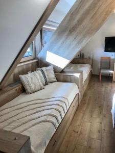 two beds in a room with a staircase at NevSki Apartments in Kopaonik