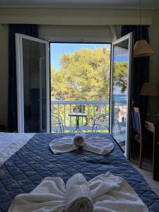 a bedroom with a bed with towels and a balcony at Theodorou Beach Hotel Apartments in Kos Town +35 photos