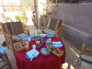 uma mesa com uma toalha de mesa vermelha e pão sobre ela em Riad Sabah em Marrakech