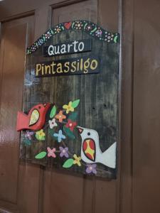 een deur met een bord waarop staat arato primasiosso bij Pousada Capão da Coruja in Santa Bárbara