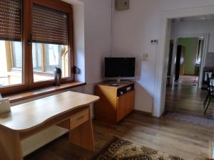 Zadora Haus في ساتشيلي: غرفة معيشة مع تلفزيون على طاولة خشبية