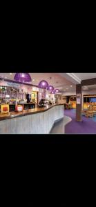 un gran vestíbulo con iluminación púrpura y un bar en Newquay Bay Porth Caravan - 6 berth, en Newquay